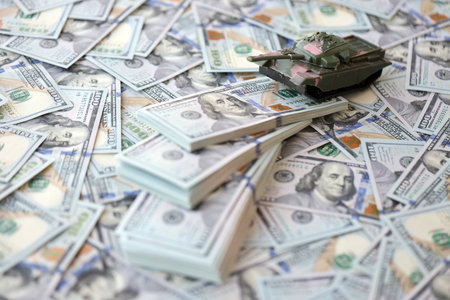 Toy tank on US hundred dollar bills banknotes close up. The concept of war costs, military spending and economic crisisの写真素材