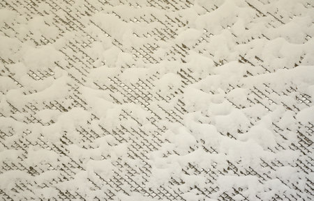 Close-up metal mesh covered with a thick layer of snow in the cells