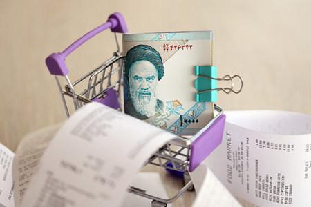 Iranian rials money bills bunch in shopping trolley surrounded by many paper receipts close up