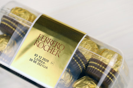 KHARKIV, UKRAINE - JANUARY 2, 2021 Ferrero Rocher - round chocolates. Candy in branded packaging, a sweet pleasure for children and adultsのeditorial素材