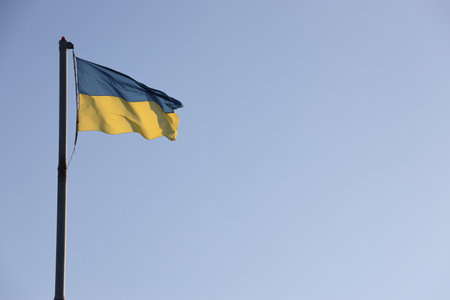 Ukraine flag large national symbol fluttering in blue sky. Large yellow blue Ukrainian state flag,...