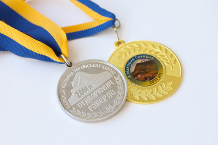 KYIV, UKRAINE - MAY 4, 2022 Medal for the person who conquered Mount Hoverla. Ukrainian tourist souvenir award on a ribbon with the colors of the Ukrainian flagのeditorial素材