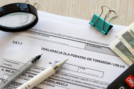 Declaration for tax on goods and services VAT-7 form on accountant table with pen and polish zloty...