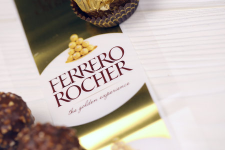 KHARKIV, UKRAINE - JANUARY 2, 2021 Ferrero Rocher - round chocolates. Candy in branded packaging, a sweet pleasure for children and adultsのeditorial素材