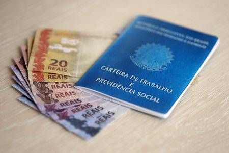 Brazilian work card and social security blue book and reais money bills close upの写真素材