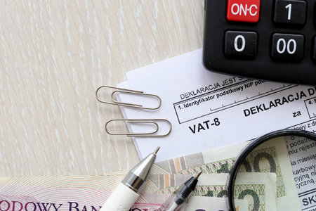 Declaration for tax on goods and services VAT-8 form on accountant table with pen and polish zloty...