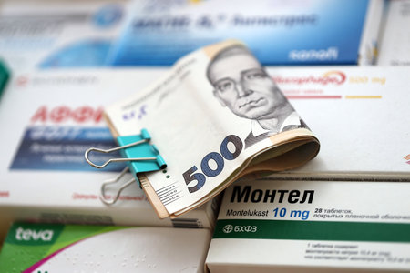 KYIV, UKRAINE - 4 MAY, 2023: Bunch of money and many boxes of pills and capsules stacked in pharmacy drug store close upのeditorial素材