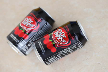 KYIV, UKRAINE - 4 MAY, 2023: Dr Pepper cherry drink black cans close up