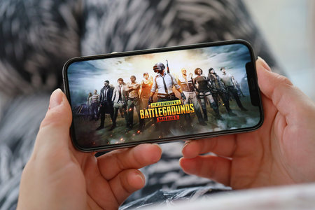 PUBG PlayerUnknowns Battlegrounds mobile iOS game on iPhone 15 smartphone screen in female hands during mobile gameplay. Mobile gaming and entertainment on portable deviceのeditorial素材