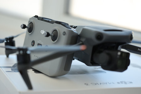 KYIV, UKRAINE - 4 MAY, 2023: new DJI Mavic 3 fly more combo quadrocopter drone on light background