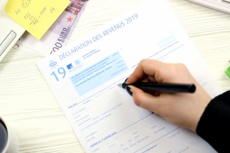 KYIV, UKRAINE - OCTOBER 31, 2023 Accountant fill french tax form 2042 income statement in end of tax...