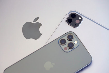 KYIV, UKRAINE - 4 MAY, 2023: Apple brand devices iphone and ipad lies on macbook body close up