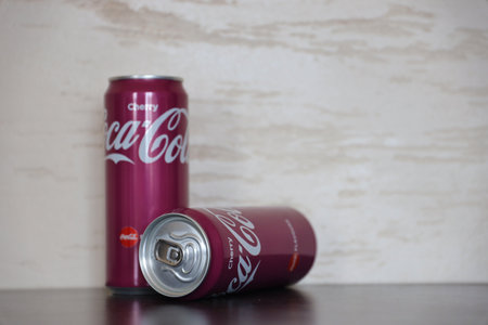 KYIV, UKRAINE - 4 MAY, 2023: Coca cola soft drinks brand tin cans with cherry flavour close up