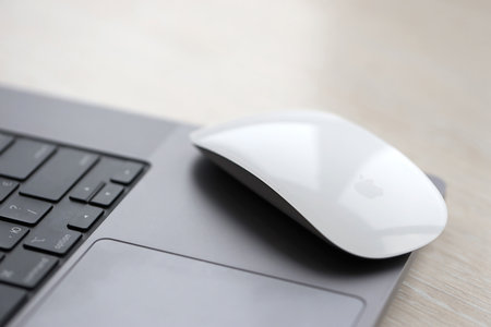 KYIV, UKRAINE - NOVEMBER 27, 2023 Apple Magic Mouse 3rd generation lies with grey MacBook 2021 close...