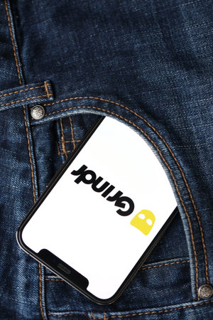 KYIV, UKRAINE - FEBRUARY 23, 2024 Grindr logo of famous dating website or app on iPhone display screen close upのeditorial素材