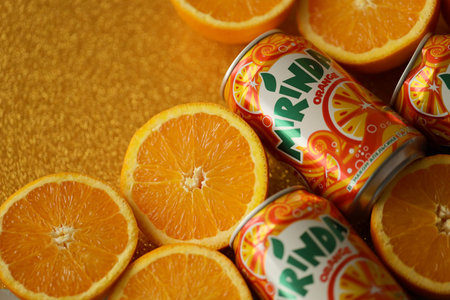 KYIV, UKRAINE - JULY 7, 2023 Mirinda orange drink with many fresh oranges on colorful backgroundのeditorial素材