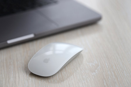 KYIV, UKRAINE - NOVEMBER 27, 2023 Apple Magic Mouse 3rd generation lies with grey MacBook 2021 close upのeditorial素材