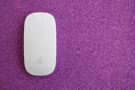 KYIV, UKRAINE - NOVEMBER 27, 2023 Apple Magic Mouse 3rd generation lies on sparkling glitter surface close upのeditorial素材