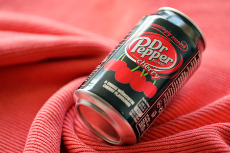 KYIV, UKRAINE - JULY 7, 2023 Dr Pepper cherry drink can on red fabric backgroundのeditorial素材