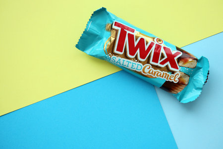 TERNOPIL, UKRAINE - JULY 7, 2023 Twix salted caramel blue wrapper on wooden background. Twix is a chocolate bar made by Mars Inc consisting of biscuit applied with caramel and milk chocolateのeditorial素材