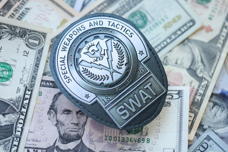 KYIV, UKRAINE - MARCH 9, 2024 US SWAT badge on many US dollar bills close upのeditorial素材