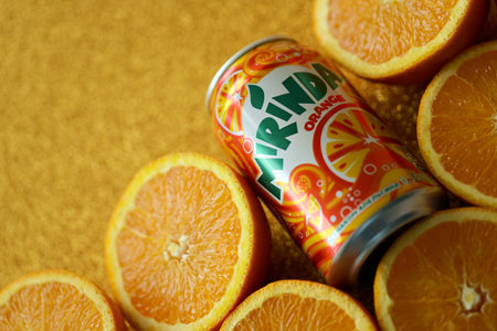 KYIV, UKRAINE - JULY 7, 2023 Mirinda orange drink with many fresh oranges on colorful backgroundのeditorial素材
