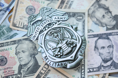 KYIV, UKRAINE - MARCH 9, 2024 US Army Military Police badge on many US dollar bills close upのeditorial素材