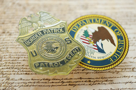 KYIV, UKRAINE - MARCH 9, 2024 US Border Patrol Agent badge and Department of Justice seal on United States Constitution close upのeditorial素材