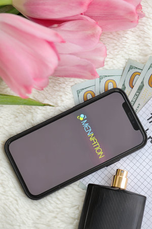 KYIV, UKRAINE - FEBRUARY 23, 2024 Mennation logo of famous dating website or app on iPhone display screen close upのeditorial素材