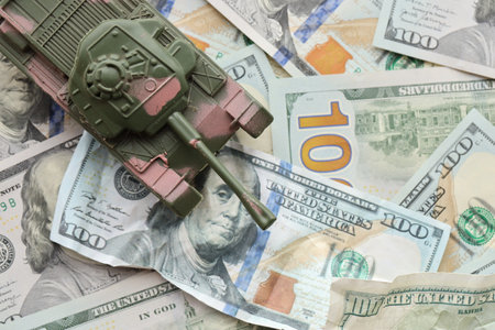 Tank on crumpled hundred dollar bills banknotes. Background of war funding and military support...