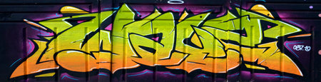 The old wall decorated with paint stains in the style of street art culture. Colorful background of full graffiti painting artwork with bright aerosol outlines on wall. Colored background textureの写真素材