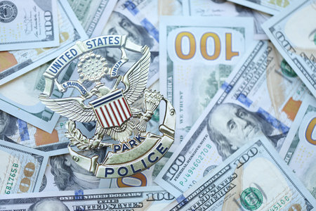 KYIV, UKRAINE - MARCH 9, 2024 US United States Park Police badge on many US hundred dollar bills...