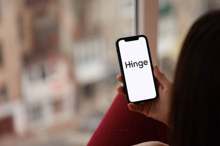 KYIV, UKRAINE - FEBRUARY 23, 2024 Hinge logo of famous dating website or app on iPhone display screen close upのeditorial素材