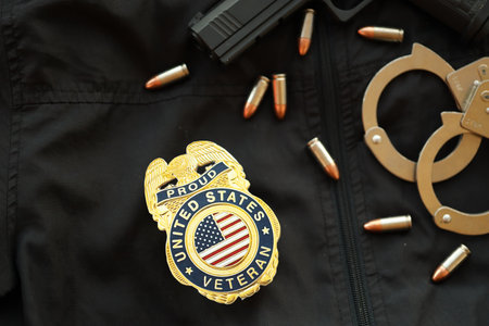 KYIV, UKRAINE - MARCH 9, 2024 US Proud Veteran badge on black jacket uniform with gun, bullets and handcuffs close upのeditorial素材