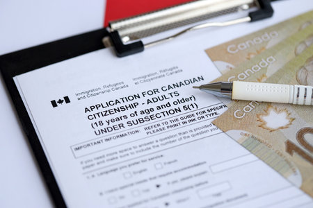 Application for Canadian citizenship for adults on table with pen and dollar bills close upの写真素材