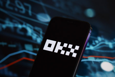KYIV, UKRAINE - MARCH 15, 2024 OKX logo on iPhone display screen and crypto currency value charts. Cryptocurrency exchange portalのeditorial素材