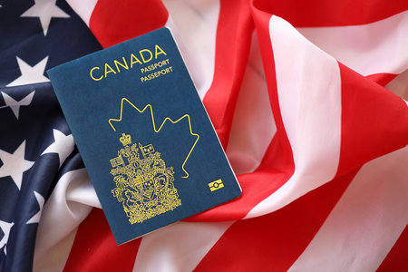 Canadian passport on United States national flag background close up. Tourism and diplomacy conceptの写真素材