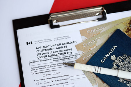 Application for Canadian citizenship for adults on table with pen, passport and dollar bills close upの写真素材