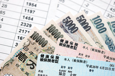 Light blue and red Japan Health Insurance cards on table with Japanese yen money close upの写真素材