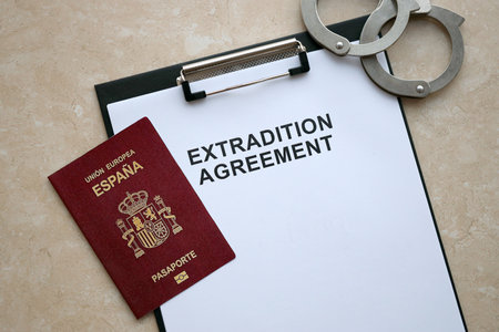 Passport of Spain and Extradition Agreement with handcuffs on table close upの写真素材