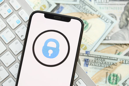 KYIV, UKRAINE - APRIL 1, 2024 OnlyFans icon on smartphone screen on many usd money bills. iPhone display with app logo and dollar banknotes with white keyboardのeditorial素材