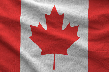 Canada flag depicted on folded wavy fabric of old cloth close upの写真素材