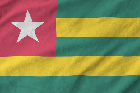 Togo flag depicted on folded wavy fabric of old cloth close upの写真素材