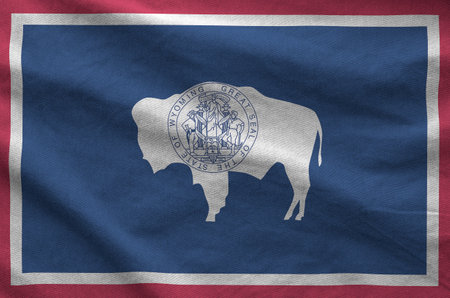 Wyoming US state flag depicted on folded wavy fabric of old cloth close upの写真素材