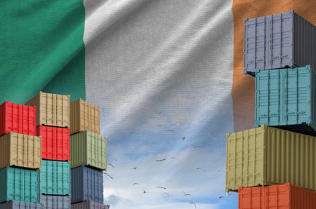 Ireland flag and big stack of shipping cargo containers in docks with sky background close upの写真素材