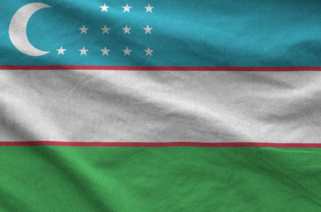 Uzbekistan flag depicted on folded wavy fabric of old cloth close upの写真素材