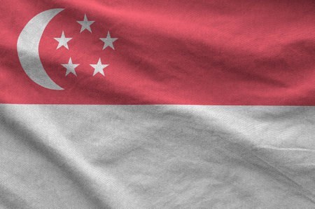 Singapore flag depicted on folded wavy fabric of old cloth close upの写真素材