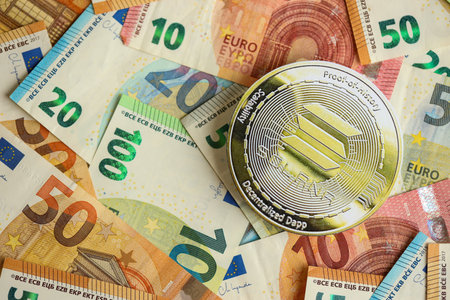 KYIV, UKRAINE - AUGUST 17, 2024 Solana SOL coin with big amount of european euro bills close upのeditorial素材