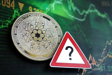 KYIV, UKRAINE - AUGUST 17, 2024 Cardano ADA coin and red paper question sign on chart background...