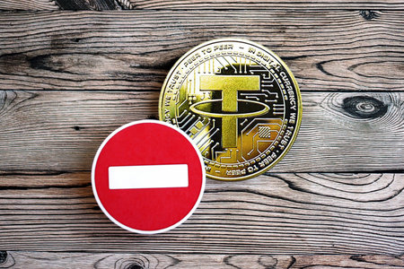 KYIV, UKRAINE - AUGUST 17, 2024 Tether USDT coin and red paper stop sign on wooden background close upのeditorial素材